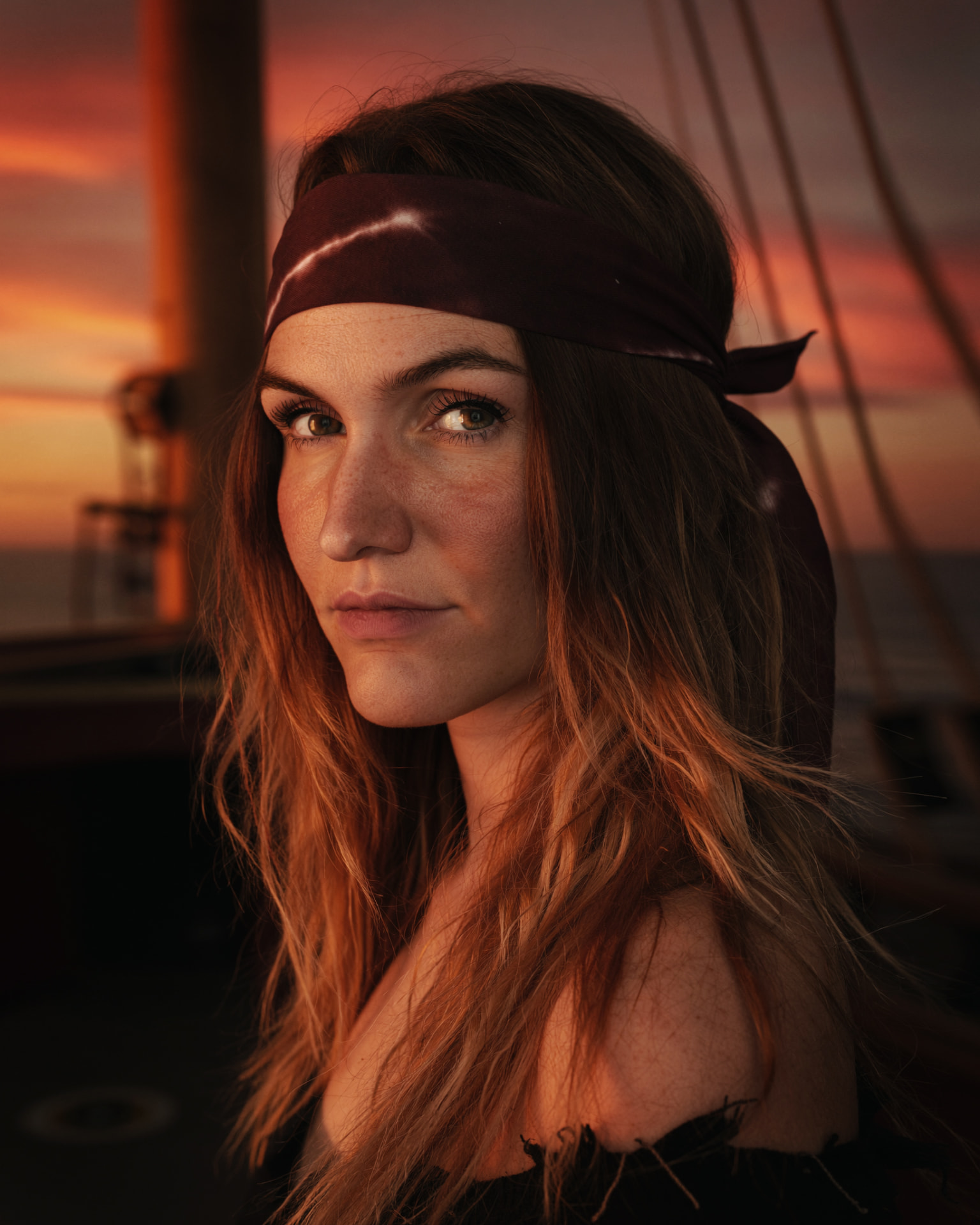 Nani im Piraten-Look mit rotem Bandana bei Sonnenuntergang auf einem Segelschiff